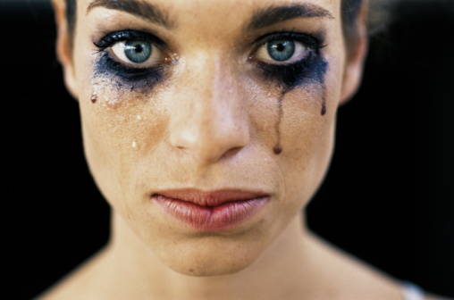 Young woman wearing black eye make-up, crying, close-up